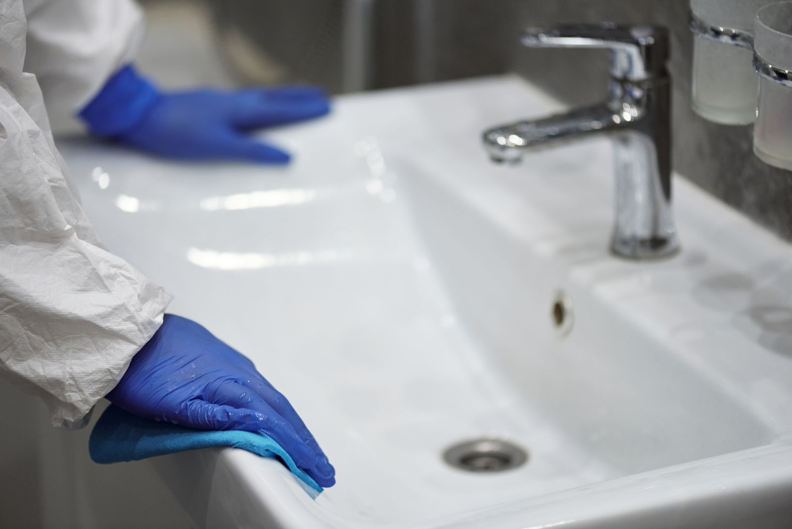 Badezimmeroberfläche wird mit Handschuhen gereinigt